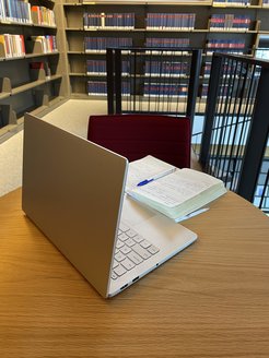 Laptop und Buch auf einem Tisch